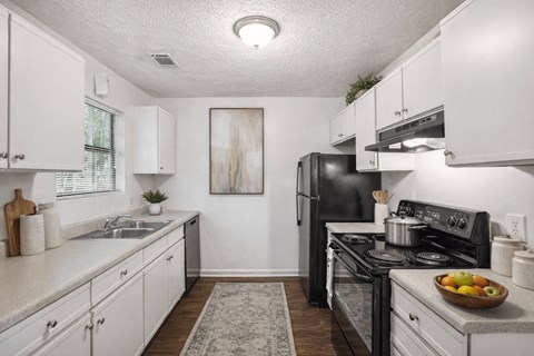 A kitchen with white cabinets and a black stove top oven.