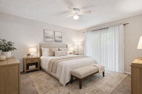 A bedroom with a large bed and a ceiling fan.