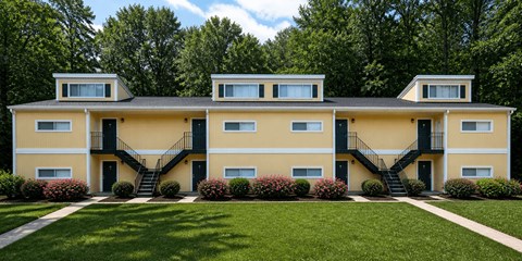 A yellow house with black railings and steps.