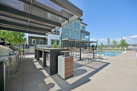 Outdoor kitchen with pool and bar seating at Sequel Homes Apartments, Englewood, CO