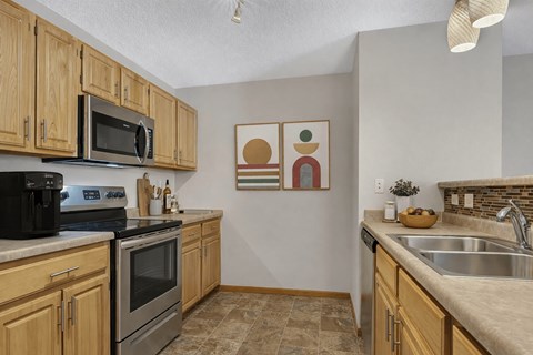 A kitchen with wooden cabinets and a black stove top oven.