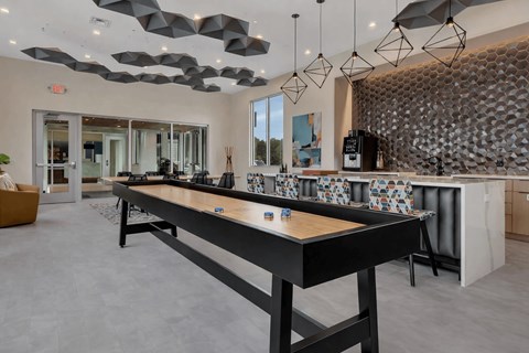 A modern kitchen with a long black table and a patterned backsplash.