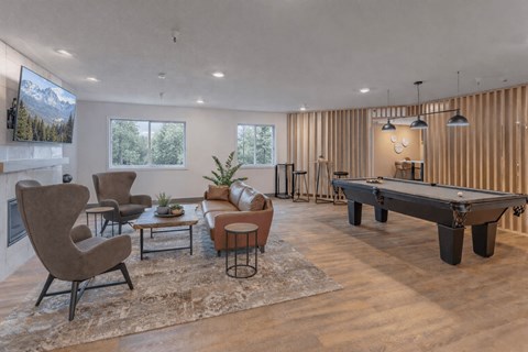 A living room with a pool table and a fireplace.