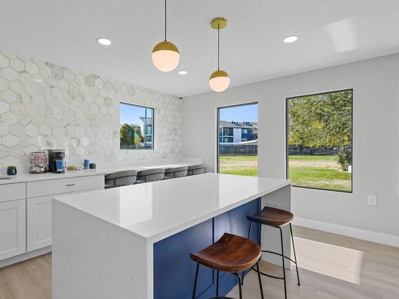 A kitchen with a white marble and hanging lights at Lexington Park Apartments, West Valley City, 84119