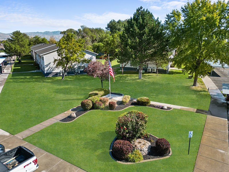 Lawn with a flag and a small garden in the middle at Lexington Park Apartments, Utah