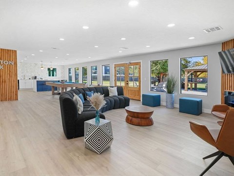 A spacious living room with a black couch and a wooden coffee table.