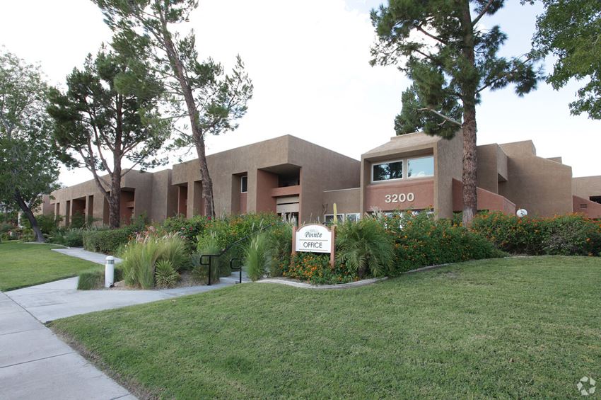 a building with a lawn and trees in front of it