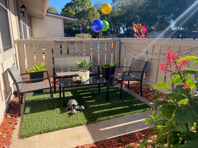 a backyard patio with a table and chairs and balloons