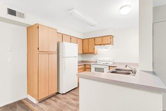 a kitchen with white appliances and wooden cabinets