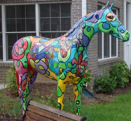 a colorful horse statue in front of a building