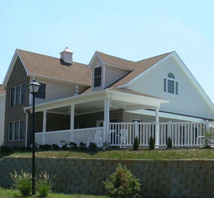 a large white house with a porch and a lamp post