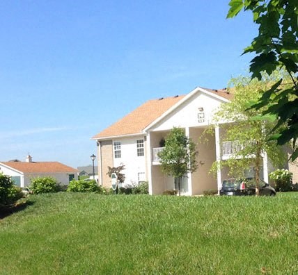 a white house with a yard in front of it