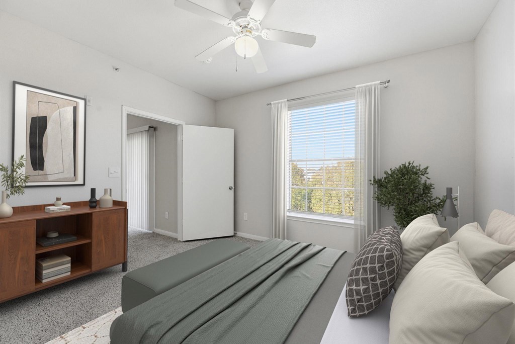 A bedroom with a bed, a dresser, a mirror, a ceiling fan, and a window with blinds.
