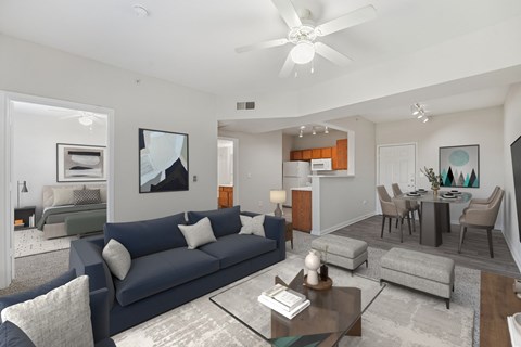 A modern living room with a dark blue sofa and a glass coffee table.