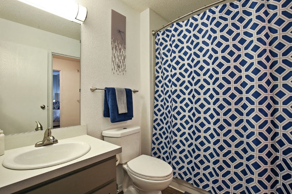 a bathroom with blue and white wallpaper and a toilet and sink