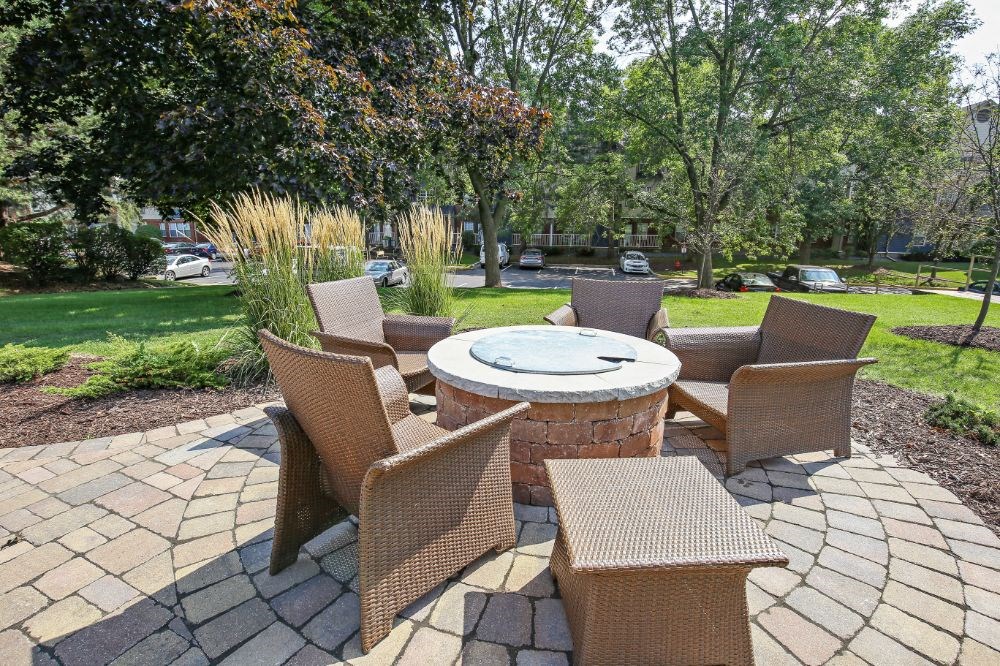 a patio with chairs and a fire pit
