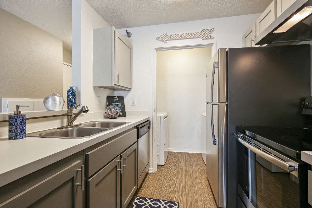 a kitchen with stainless steel appliances and a black refrigerator