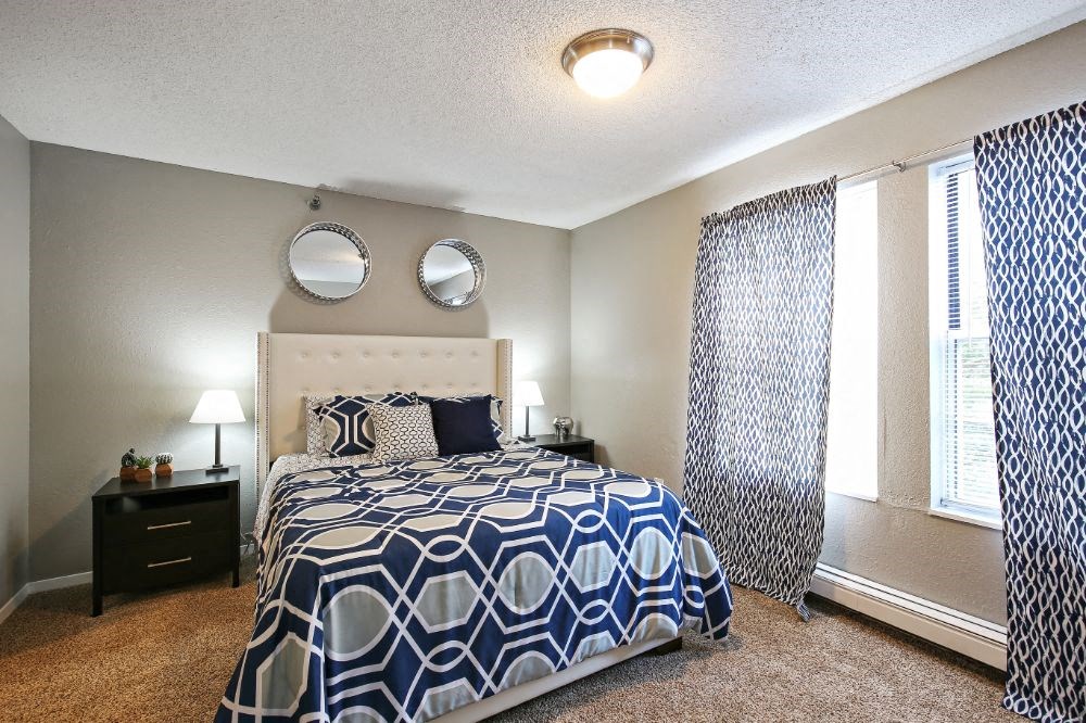 a bedroom with a bed and two windows