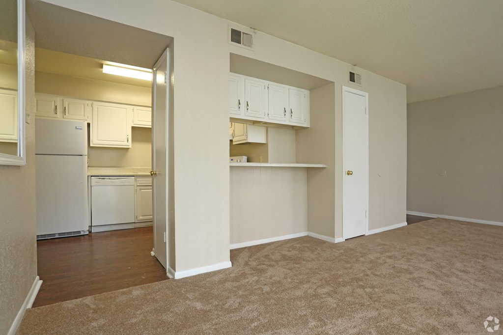 an empty living room with a kitchen in the background at The Wilshire, Lake Charles, LA