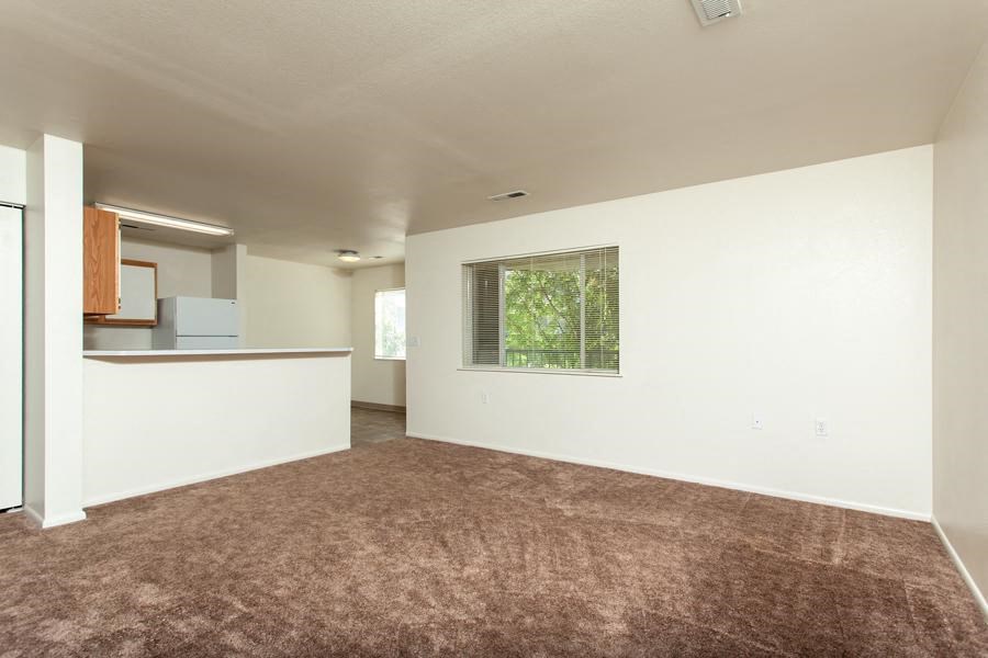an empty living room with white walls and a window