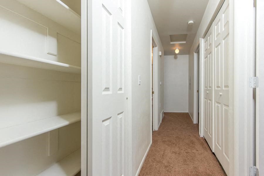 a hallway with white closets and a carpeted floor