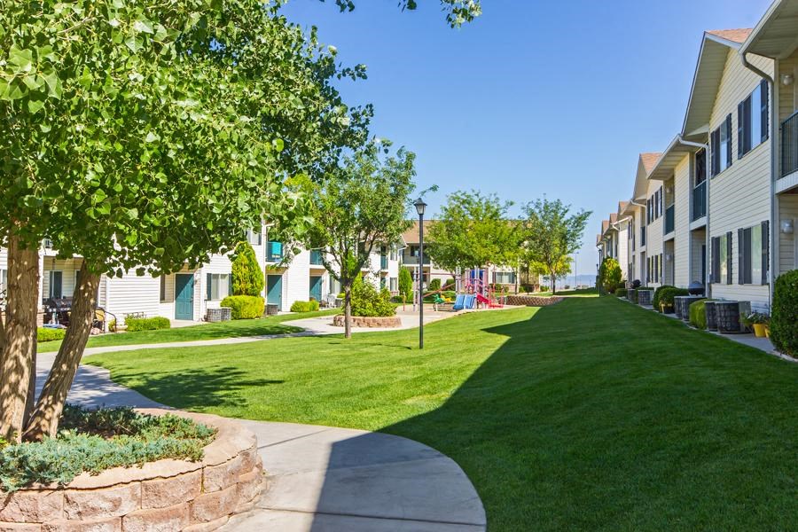 a sidewalk in front of a row of houses