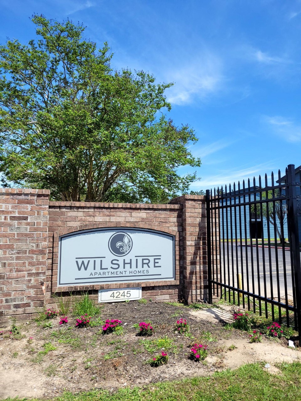 a sign that says wilshire at the entrance of the property at The Wilshire, Lake Charles