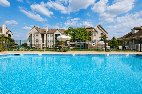 A large swimming pool in front of a residential area.
