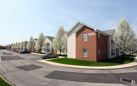 an apartment building on the corner of a parking lot