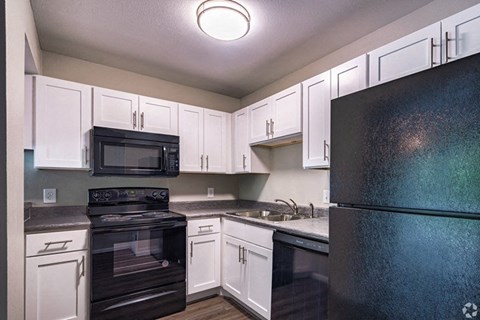 a kitchen with black appliances and white cabinets