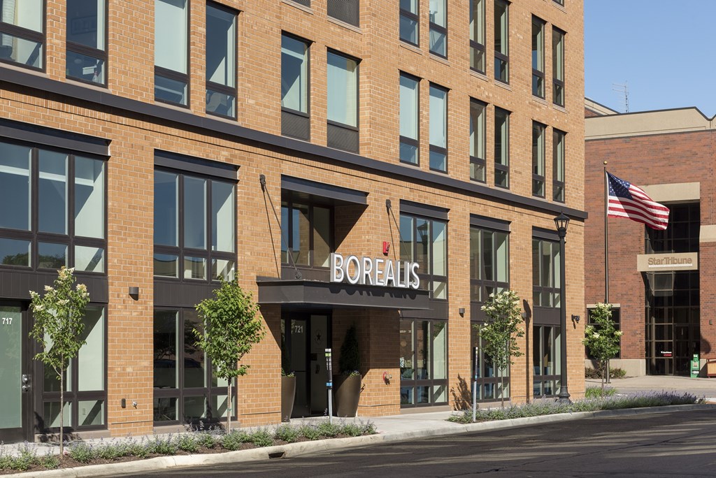 A Borelis storefront with a brick facade and an American flag.