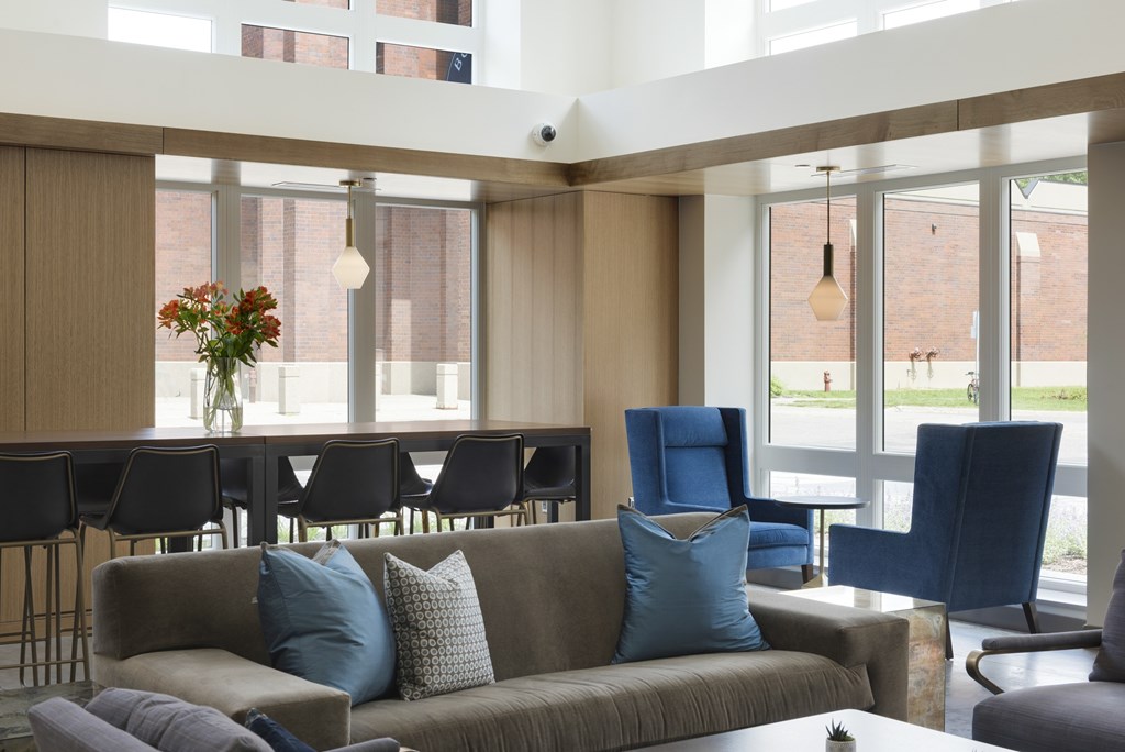 A living room with a grey couch and blue chairs.