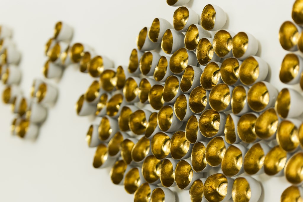 A cluster of gold and white spheres are arranged in a pattern.
