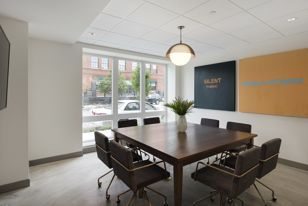 A conference room with a long table and chairs.