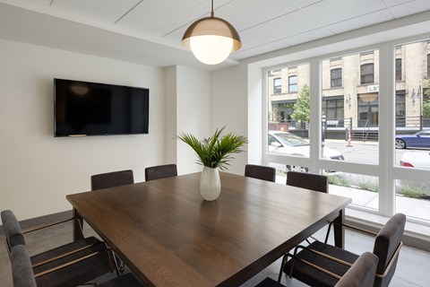 A conference room with a large table and chairs.