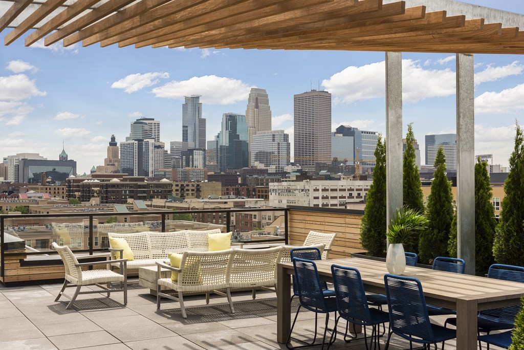 A patio with chairs and a table overlooking a city skyline.
