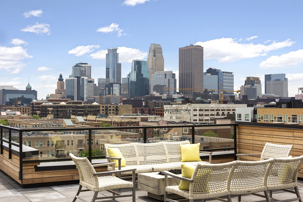 A patio with a table and chairs overlooking a city skyline.