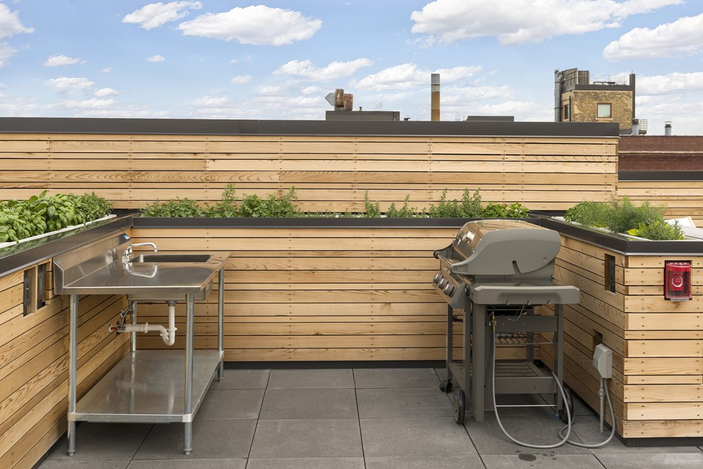 A small outdoor kitchen with a sink and grill.