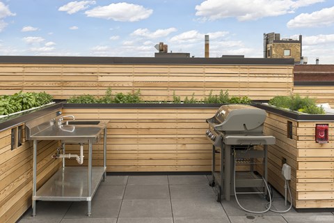 A small outdoor kitchen with a sink and grill.