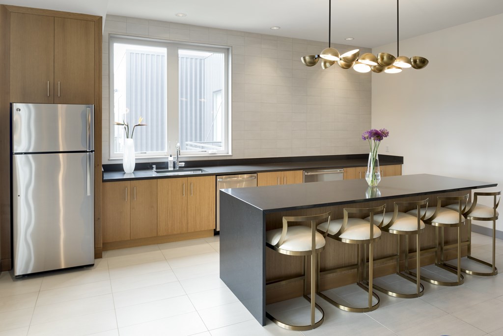 A modern kitchen with a large island and stools.