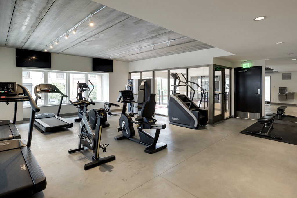 A gym with treadmills, elliptical machines, and other exercise equipment.