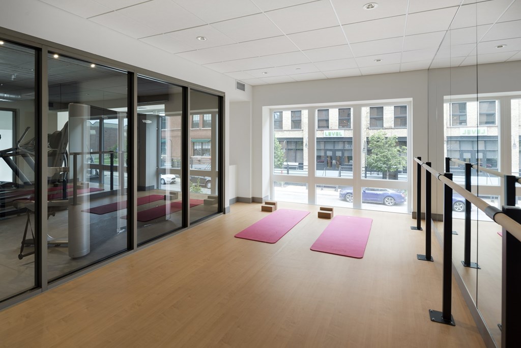 A yoga studio with pink mats and glass walls.