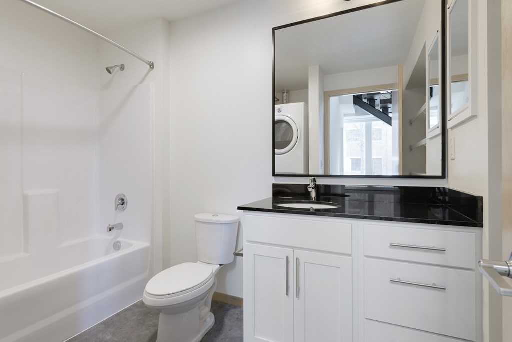 A white bathroom with a toilet, sink, and bathtub.