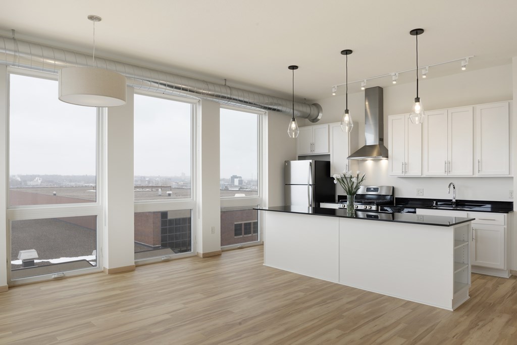 A modern kitchen with a large island and a view of the city.