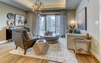 The Christopher at The Union | Luxury Apartments in Dallas, TX Sizable Model Living Room with Hardwood Style Flooring and Craft Ceilings with Lit Coves - Photo Gallery 3