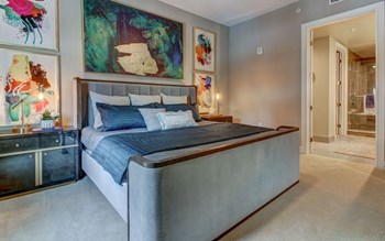 The Christopher at The Union | Luxury Apartments in Dallas, TX Spacious Model Bedroom with Carpeted Flooring and Natural Light - Photo Gallery 4