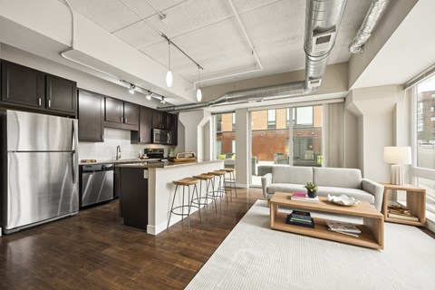 A modern kitchen with dark wood cabinets and stainless steel appliances.