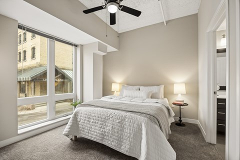 A bedroom with a large bed and a ceiling fan.