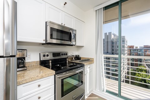 A kitchen with white cabinets and stainless steel appliances.