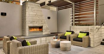 a patio with chairs and a fireplace